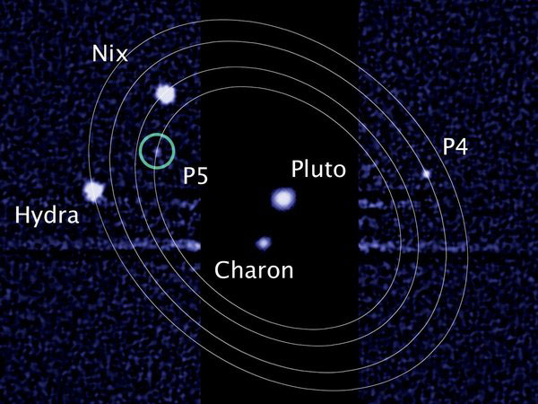 An image from the Hubble Space Telescope showing Pluto and its largest moon, Charon, along with four smaller moons.