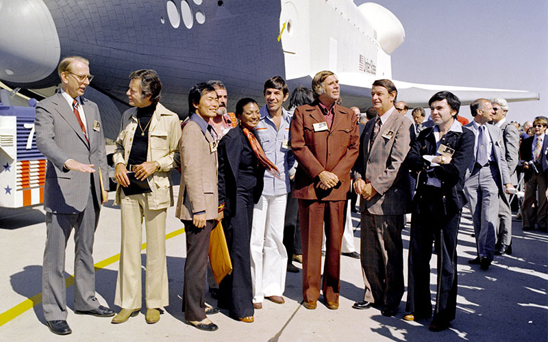 Standing with NASA’s first space shuttle “Enterprise,” Nichols, Star Trek creator Gene Roddenberry, and members of the original series cast at the shuttle’s rollout ceremony in 1976.