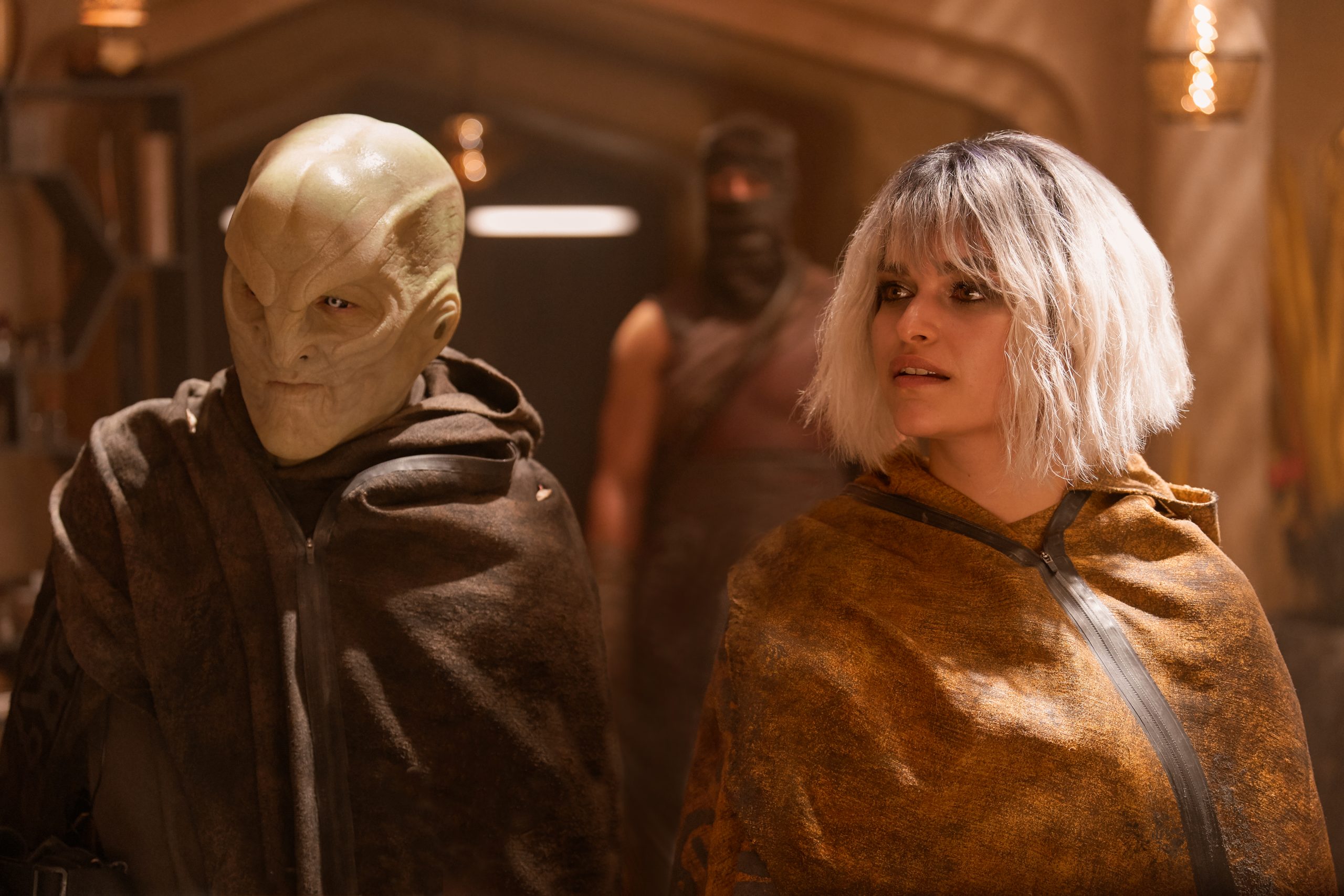 Elias Toufexis as L’ak and Eve Harlow as Malinne Ravel
